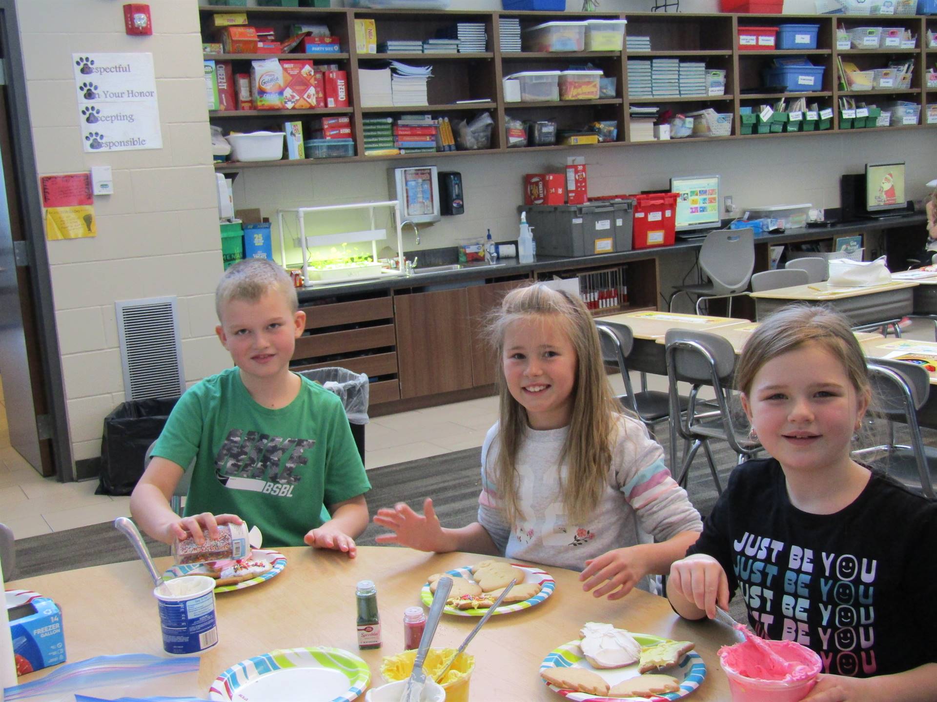 3 students decorating Christmas cookies