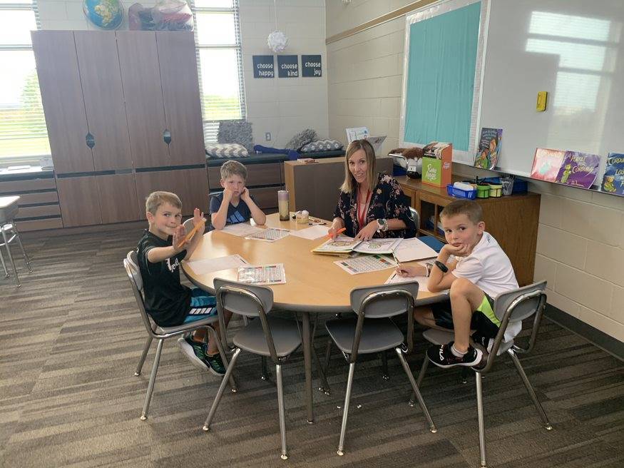 3 boys at table with 2nd grade teacher