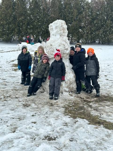 Students build a snowman at recess