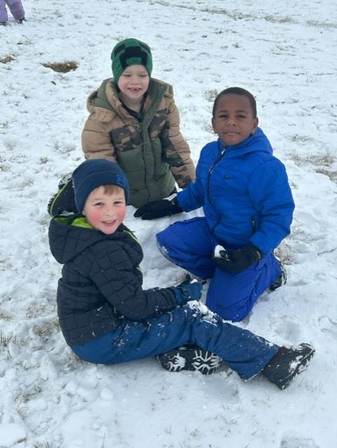 Kindergarten boys play in snow at recess