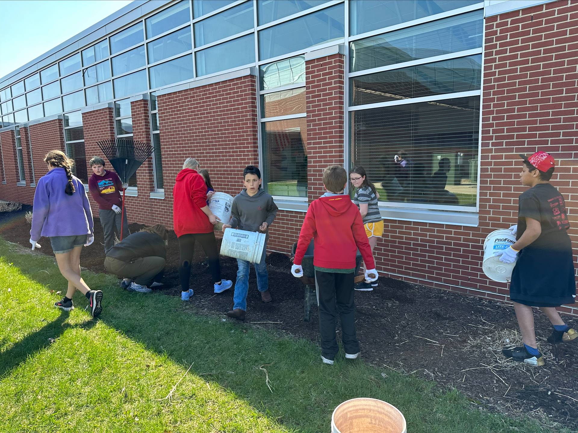 bobcat service day - students spreading mulch around DES building